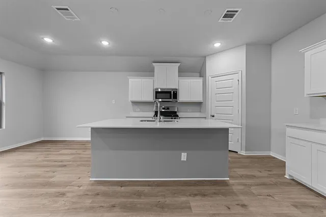 a view of kitchen with granite countertop cabinets and refrigerator