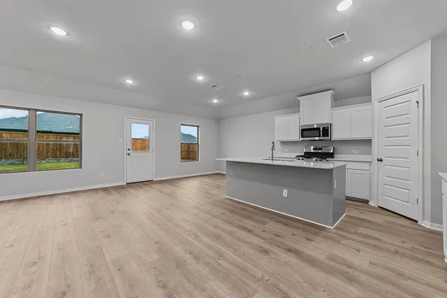 a kitchen with granite countertop white cabinets and white appliances