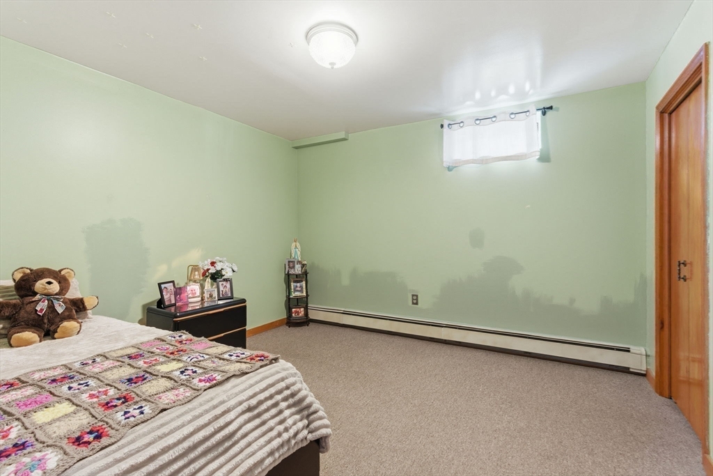 71-73 Oak Street Somerville, MA 02143 - Photo 20 of 42 a bedroom with a bed and a chandelier