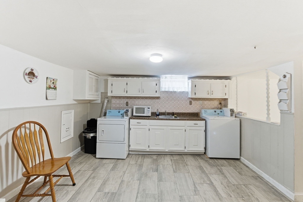 71-73 Oak Street Somerville, MA 02143 - Photo 24 of 42 a kitchen with a cabinets and chairs