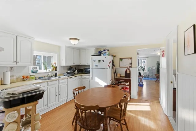 a kitchen with stainless steel appliances a dining table chairs and stove top oven