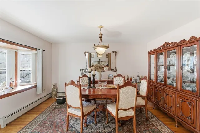 a dining room with furniture a chandelier and wooden floor