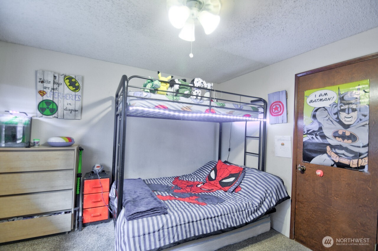 8548 178th Avenue Southwest Rochester, WA 98579 - Photo 21 of 30 a bedroom with a bed and a chandelier