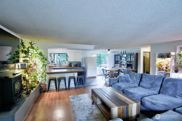 a living room with furniture a fireplace and a dining table with wooden floor