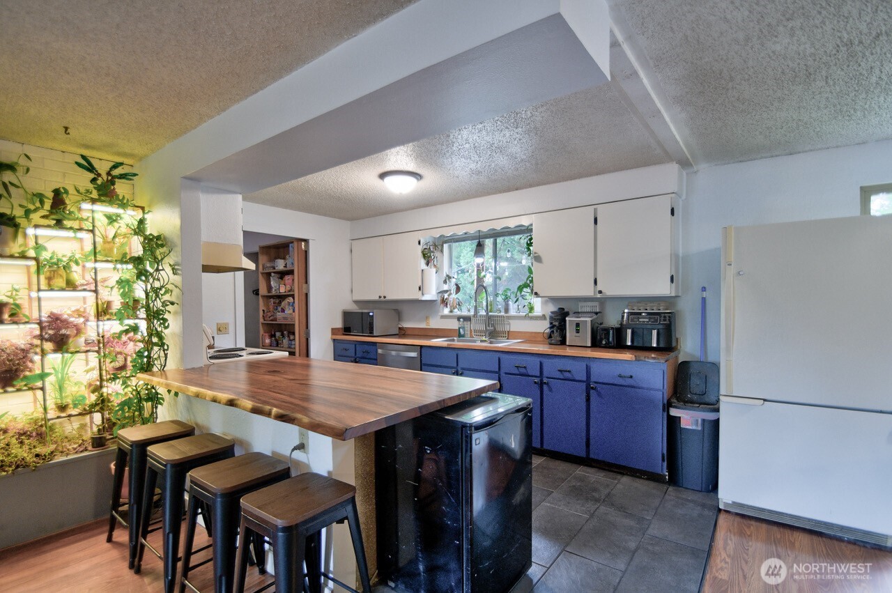 8548 178th Avenue Southwest Rochester, WA 98579 - Photo 10 of 30 a kitchen with granite countertop a table chairs stove and refrigerator