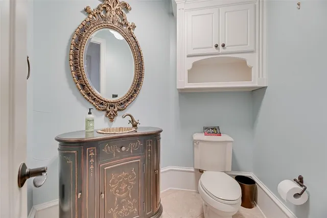 a bathroom with a toilet a sink and a mirror