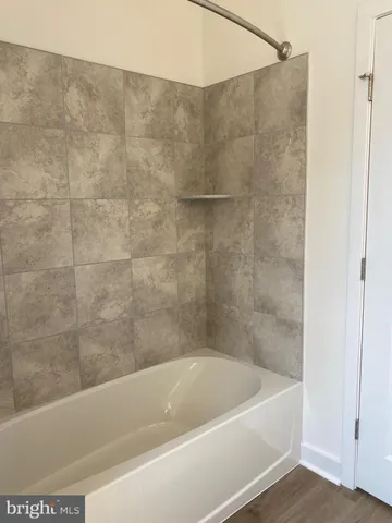 a bath tub sitting next to a white sink and a shower