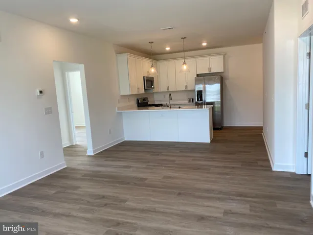a view of kitchen with wooden floor and electronic appliances