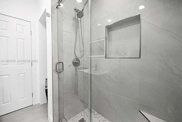 a bathroom with a shower and a glass door