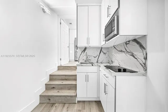 a view of a kitchen with white cabinets and white appliances