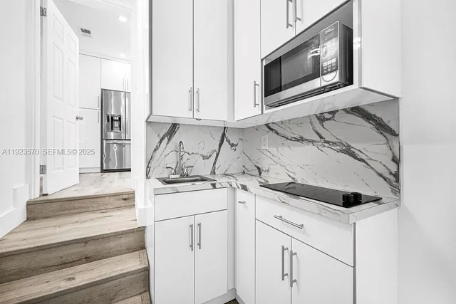 a kitchen with granite countertop white cabinets and white appliances