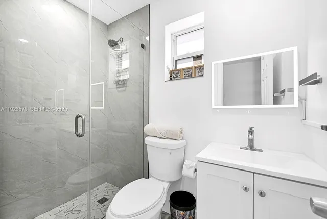 a white toilet sitting next to a bathroom sink