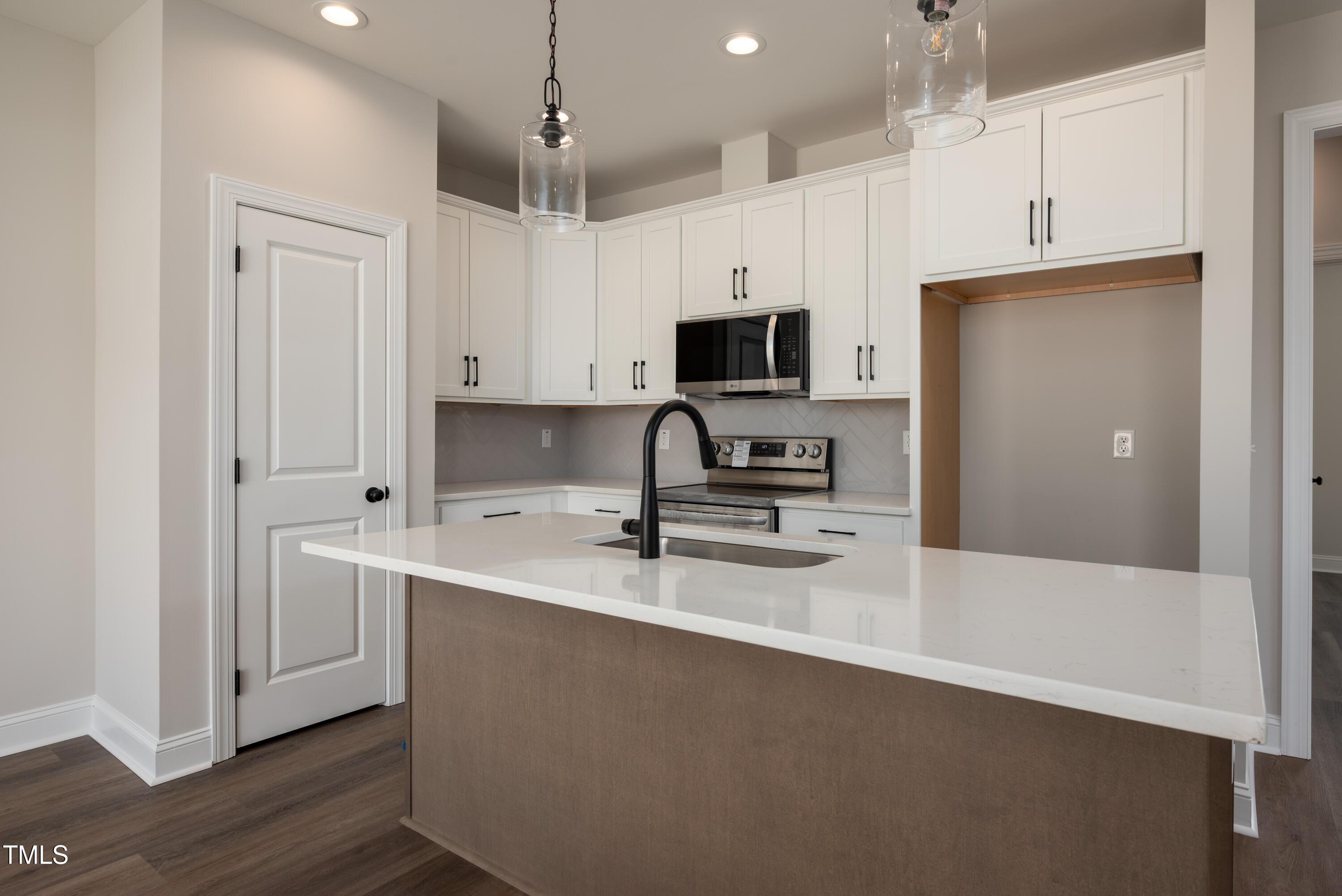 9618 Stallings Road Spring Hope, NC 27882 - Photo 5 of 31 a kitchen with kitchen island a sink stainless steel appliances and white cabinets
