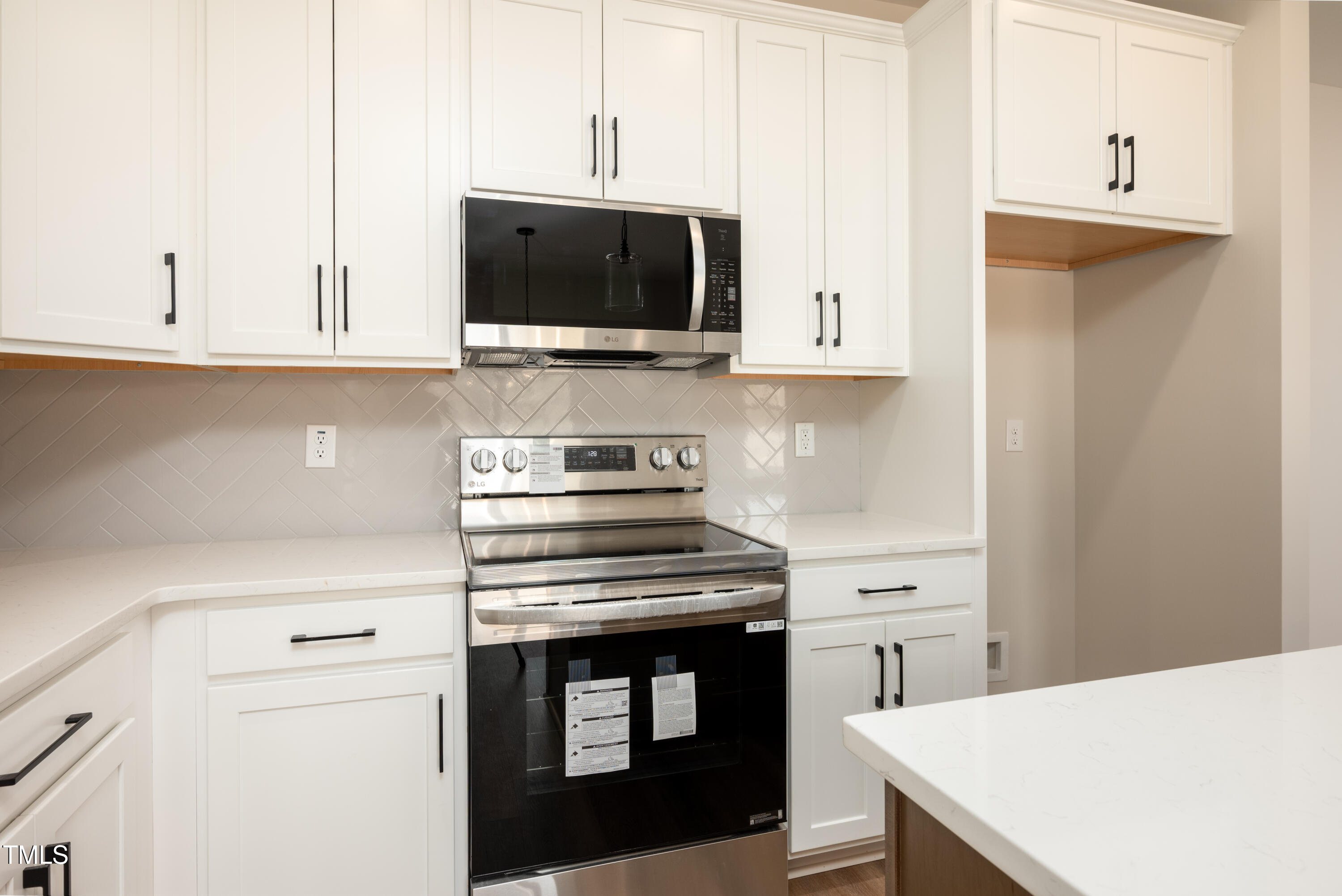 9618 Stallings Road Spring Hope, NC 27882 - Photo 6 of 31 a kitchen with stainless steel appliances a stove a microwave and cabinets