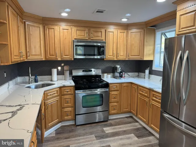 a kitchen with stainless steel appliances granite countertop a refrigerator sink and stove