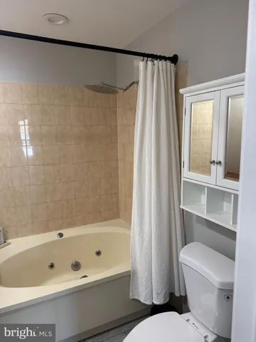 a bathroom with a bathtub a toilet and a shower