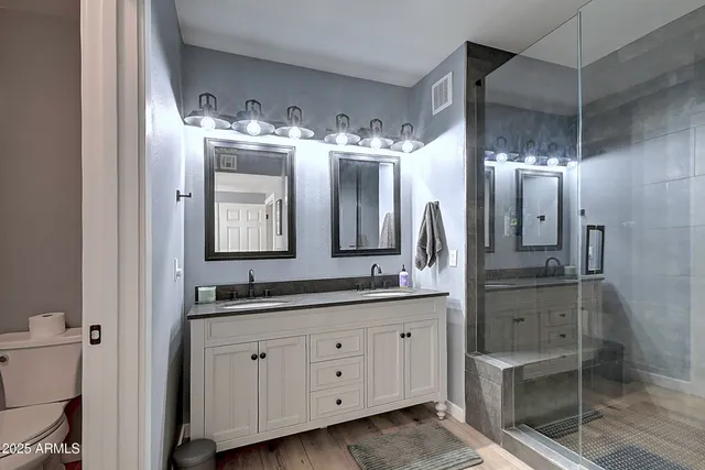 a bathroom with double vanity and a mirror