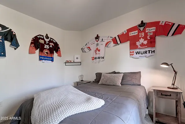 a bedroom with a bed and painting on the wall