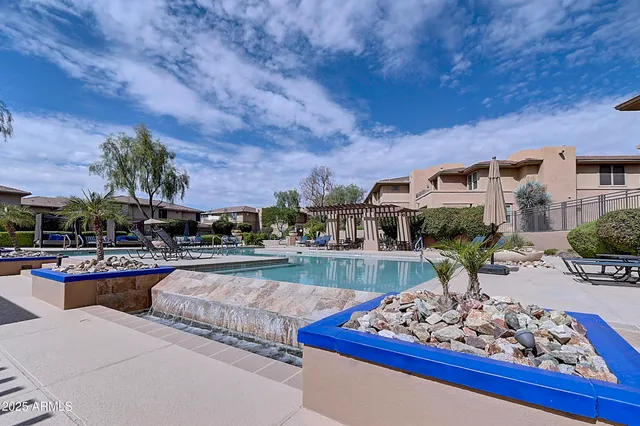 a view of a patio with table and chairs potted plants and a large tree