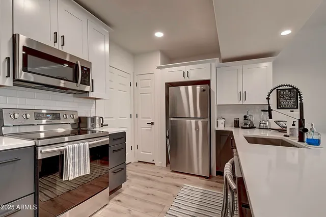 a kitchen with stainless steel appliances granite countertop a refrigerator sink and cabinets