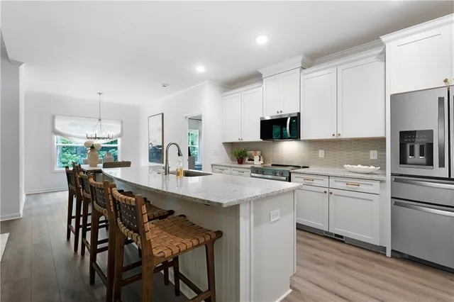 a kitchen with appliances cabinets and wooden floor