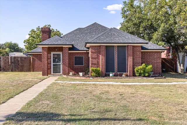 a front view of a house with a yard and potted plants