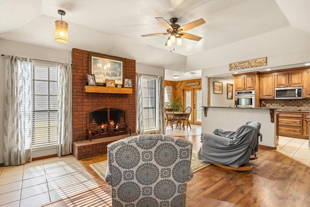 614 Overhill Road Granbury, TX 76048 - Photo 12 of 40 a living room with furniture a fireplace and a flat screen tv