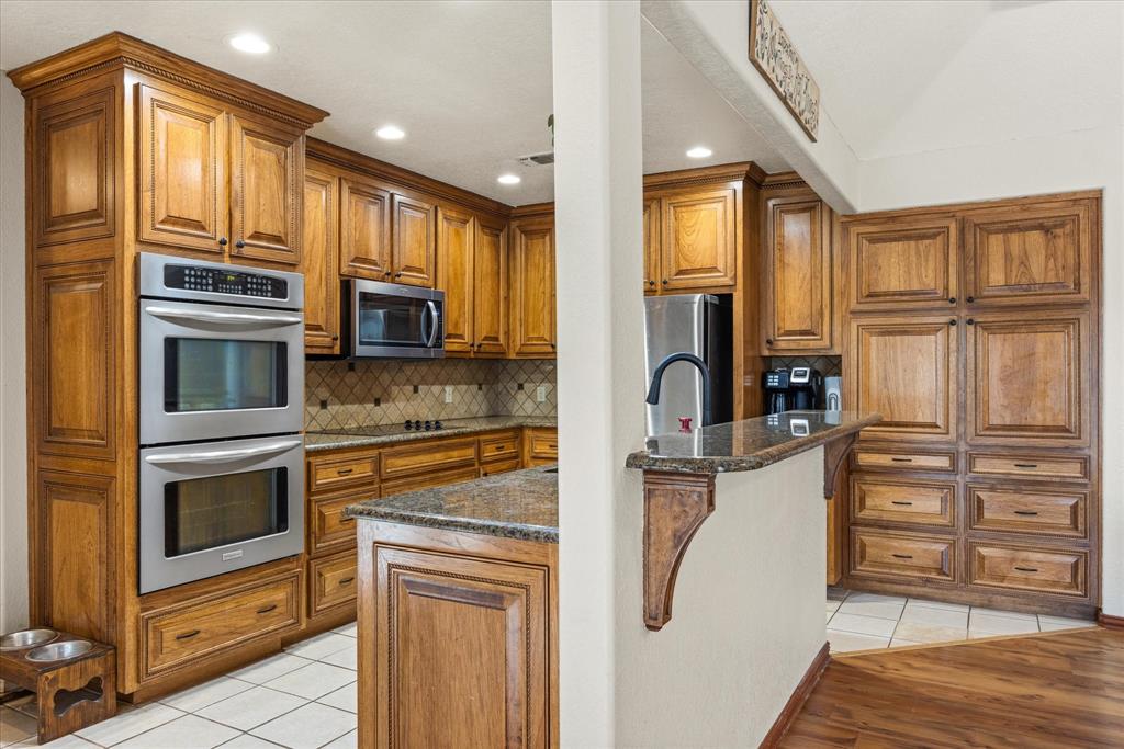 614 Overhill Road Granbury, TX 76048 - Photo 19 of 40 a kitchen with stainless steel appliances granite countertop a refrigerator and a stove top oven