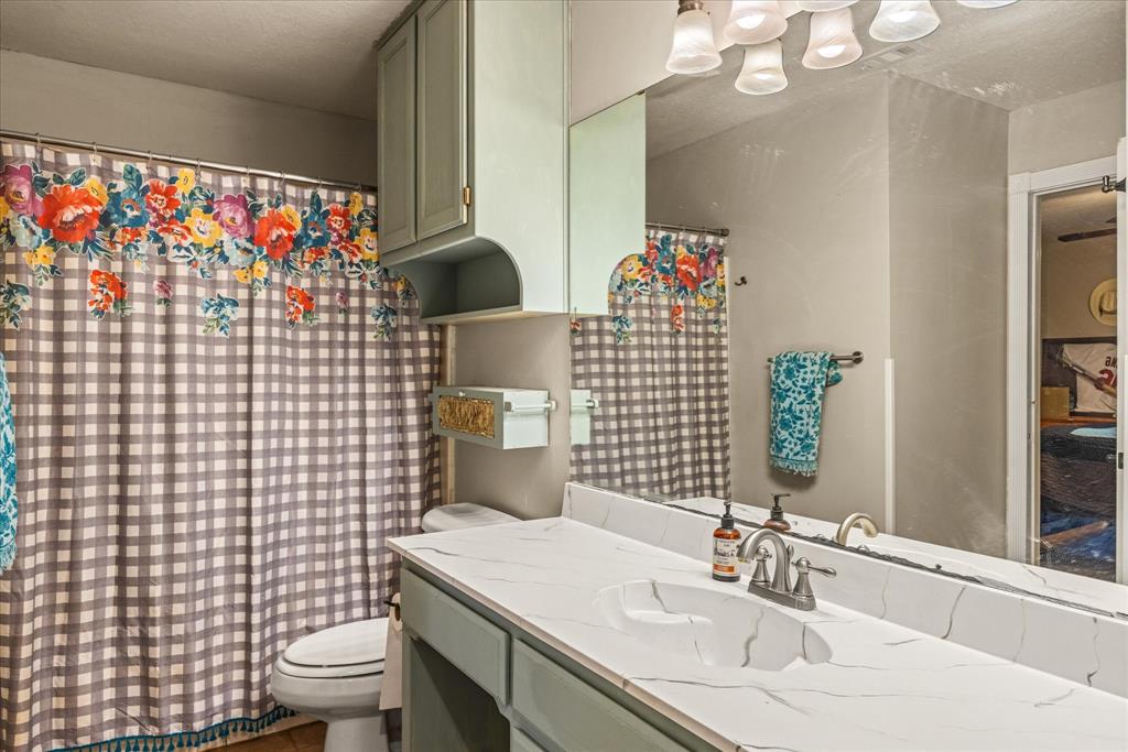 614 Overhill Road Granbury, TX 76048 - Photo 22 of 40 a bathroom with a sink toilet and shower