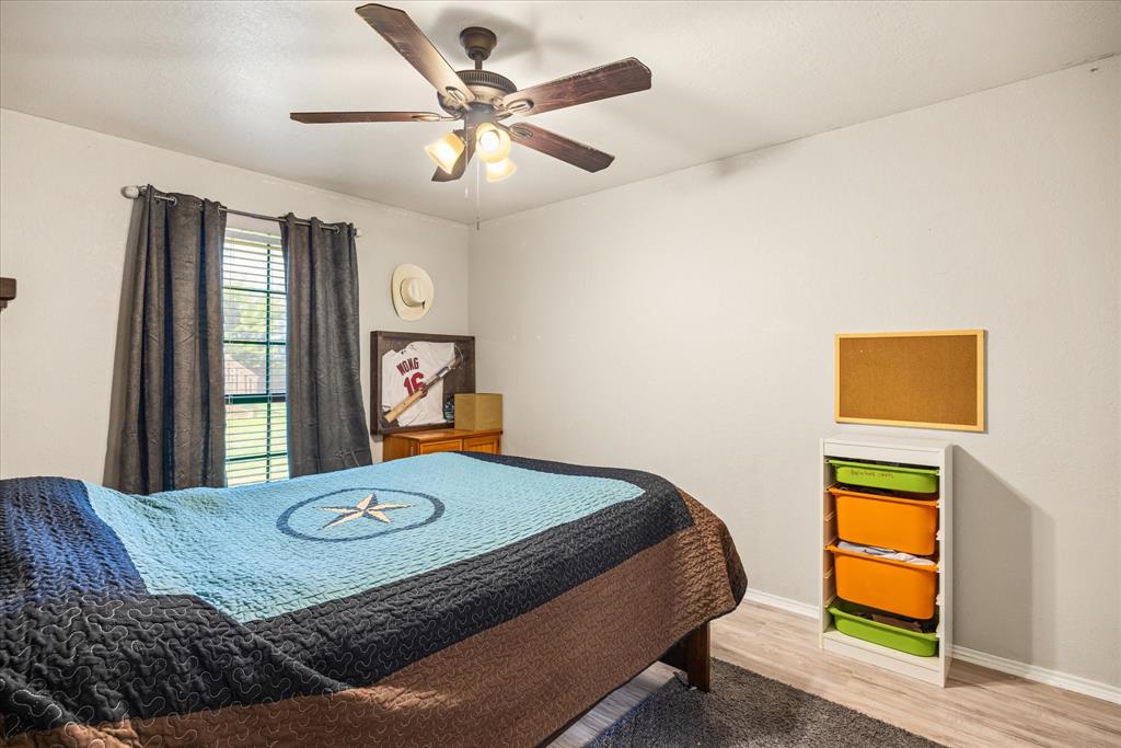 614 Overhill Road Granbury, TX 76048 - Photo 23 of 40 a bedroom with a bed and dresser