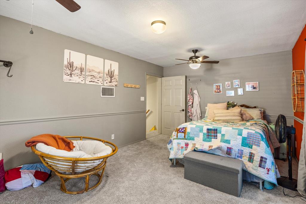 614 Overhill Road Granbury, TX 76048 - Photo 28 of 40 a bedroom with furniture and a chandelier