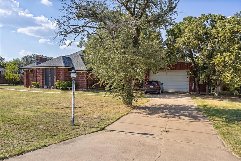 614 Overhill Road Granbury, TX 76048 - Photo 3 of 40 a front view of a house with a yard and garage