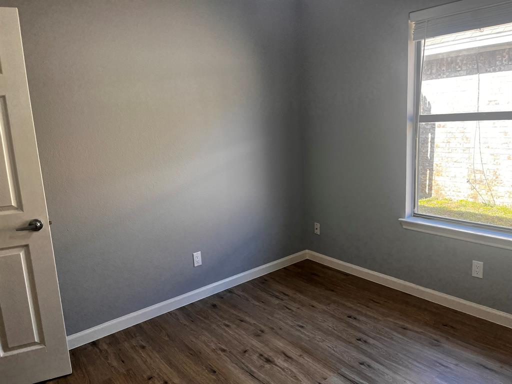 1007 Mack Place Denton, TX 76209 - Photo 30 of 37 Unfurnished room with dark wood-type flooring and baseboards