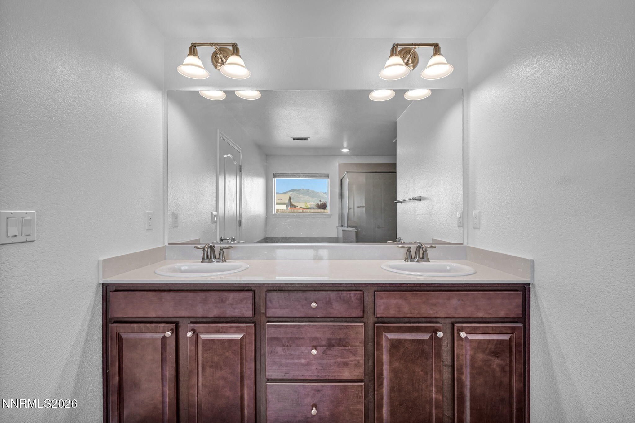 7181 Saddlehorn Road Carson City, NV 89701 - Photo 43 of 62 a bathroom with a sink a mirror and a light fixture