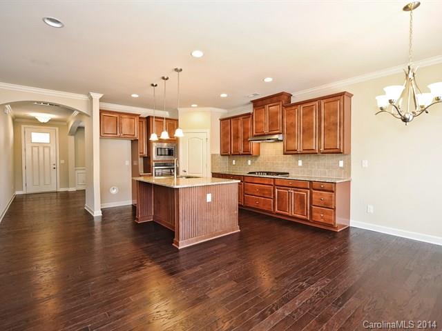 1515 Hazel Street, Unit 319 Tega Cay, SC 29708 - Photo 3 of 23 a large kitchen with stainless steel appliances kitchen island granite countertop a stove a sink and a refrigerator