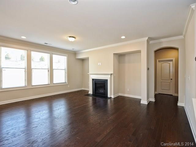 1515 Hazel Street, Unit 319 Tega Cay, SC 29708 - Photo 8 of 23 an empty room with wooden floor fireplace and windows