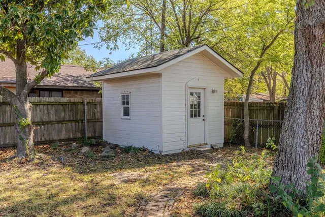 a view of a house with a yard and large tree
