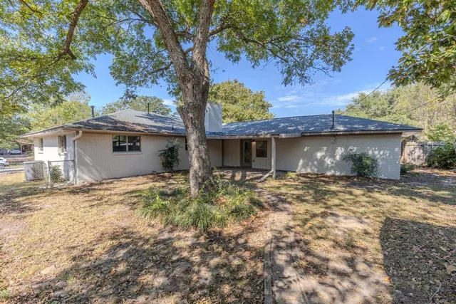 a view of a house with a tree and a yard