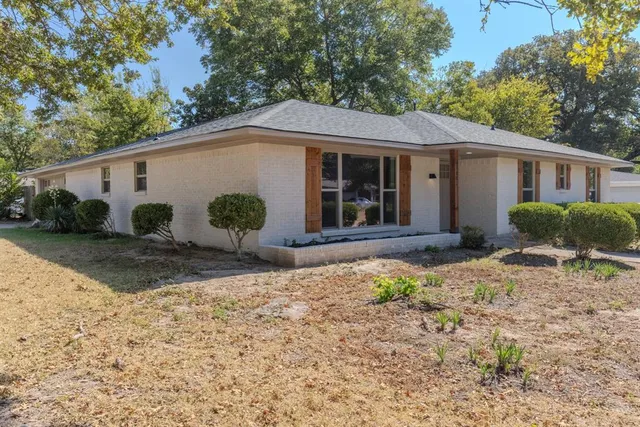 a view of a house with backyard and trees