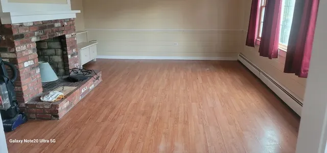 a view of a room with wooden floor and a fireplace
