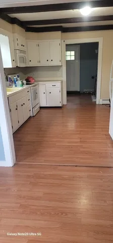 a kitchen with cabinets stainless steel appliances and wooden floor
