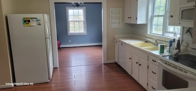 an empty room with wooden floor and cabinets