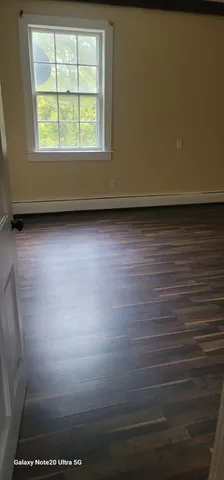 a view of a room with wooden floor and a window
