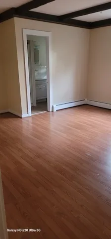 an empty room with wooden floor and door