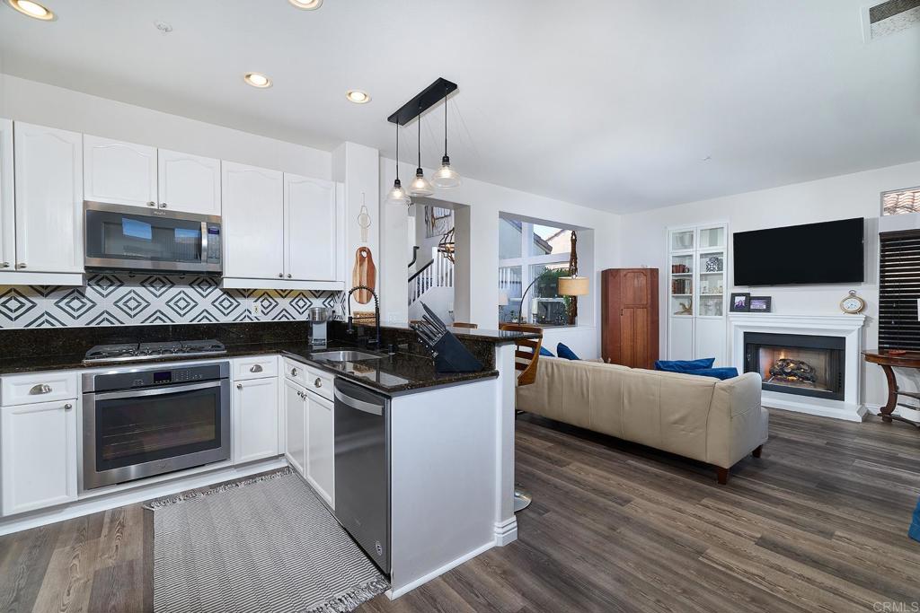 2414 Fallbrook Place Escondido, CA 92027 - Photo 32 of 63 a kitchen with stainless steel appliances a stove a microwave a sink and cabinets