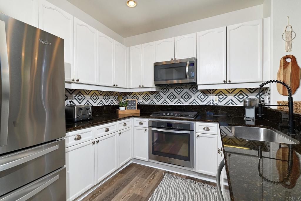 2414 Fallbrook Place Escondido, CA 92027 - Photo 34 of 63 a kitchen with granite countertop a refrigerator stove and microwave