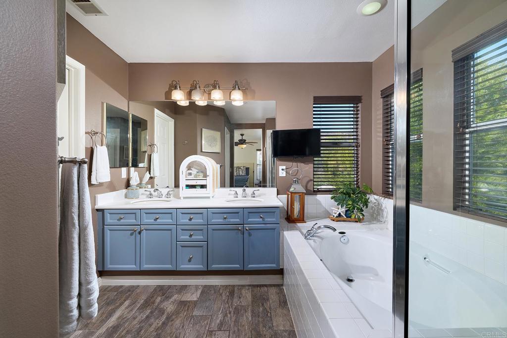 2414 Fallbrook Place Escondido, CA 92027 - Photo 38 of 63 a bathroom with a tub double vanity sink and a large mirror