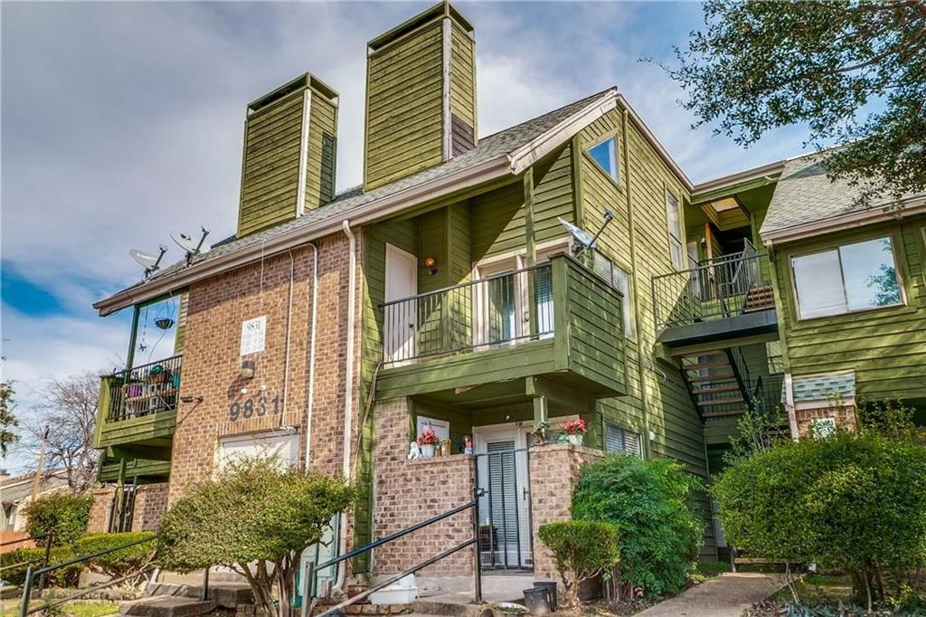 a view of a house with a small yard and potted plants