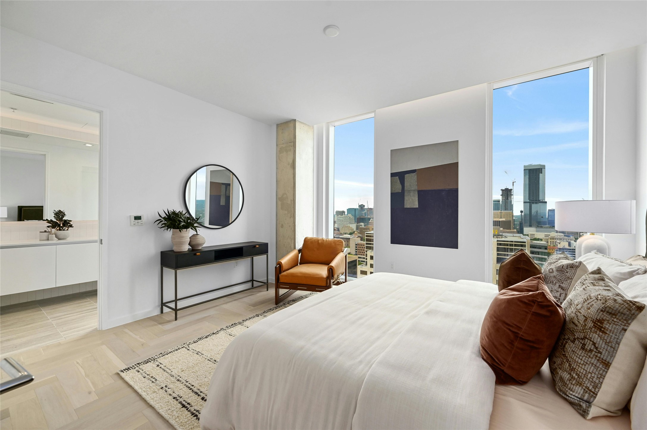 313 West 17th Street, Unit 1807 Austin, TX 78701 - Photo 1 of 39 The primary bedroom is a sanctuary of modern luxury and scenic beauty. Floor-to-ceiling glass panels frame stunning panoramic views, creating a tranquil and visually striking environment.