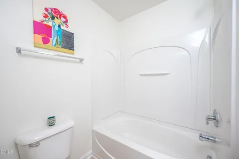a bath tub sitting next to a white toilet and sink